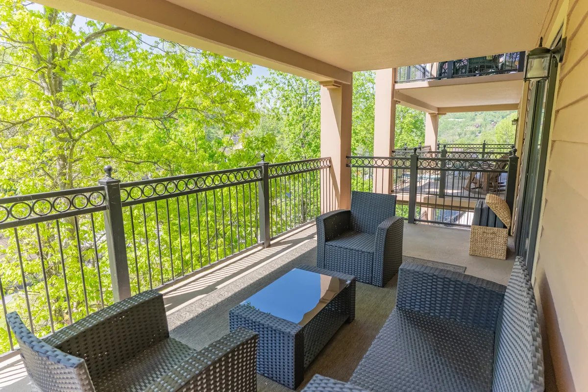 An inviting outdoor seating area surrounded by lush greenery. The reflective tabletop and modern chairs suggest a space ideal for morning coffee, evening drinks, or socializing with friends after a day of adventure.