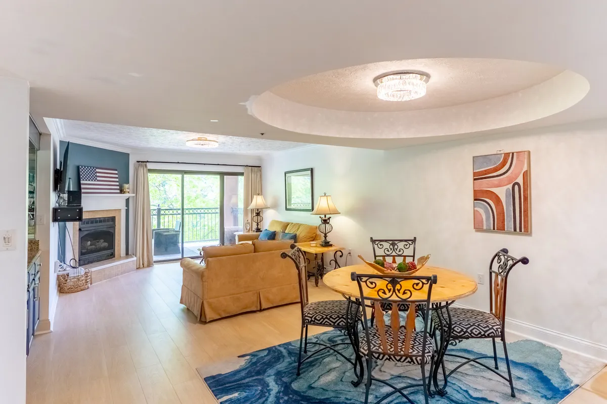 A living room scene featuring a comfortable sofa, a dining table, and a fireplace. Natural light streams in through the window, creating a bright and inviting mood. The furniture is arranged for conversation and sharing, ideal for the kind of family fun or romantic moments described in the section.